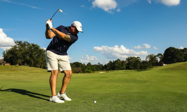 Someone about to take a swing at a golf ball.
